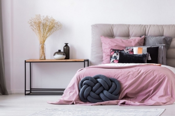 Pastel pink bedding on king size bed in cozy bedroom interior