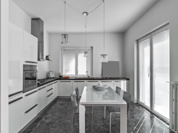 interiors of a modern kitchen with white lichen cabinets, in the center of the room there is the dining table the floor is made in marble